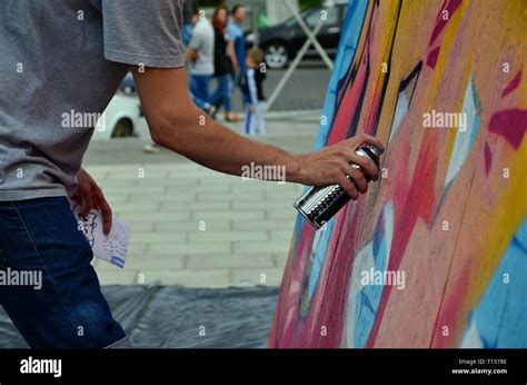 eine junge graffiti künstler malt ein neues graffiti an der wand foto der prozess des zeichnens