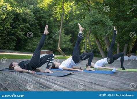 Group Of Women Practice Yoga Lying On Yoga Mat Exercise With The Leg