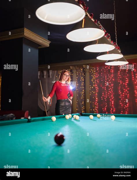 Billiard Club A Woman With In Glasses With Red Hair And Nice Figure Standing By The Table Stock