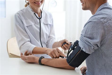 Doctor Checking Patient`s Blood Pressure In Hospital Closeup Stock
