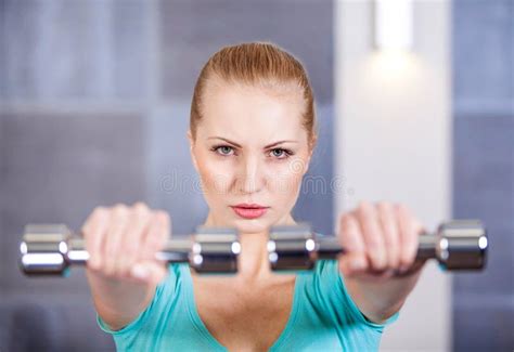 Young Woman Exercising With Dumbbells At The Gym Training Shoulders