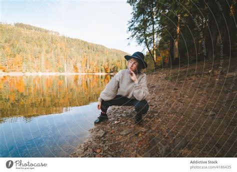 Unrecognizable Traveler Enjoying Lake Reflecting Trees During Vacation