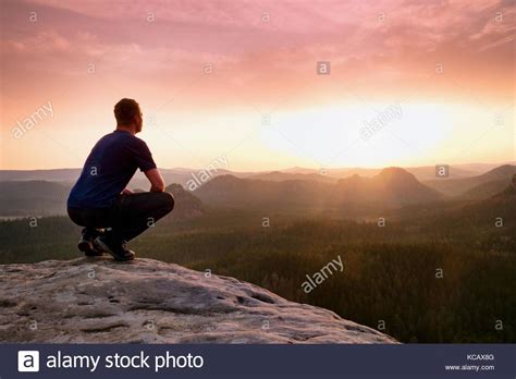 Moment Of Loneliness Man Sit On The Peak Of Rock And Watching Into