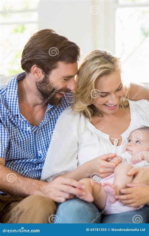 Parents Sitting On Sofa With Their Child Stock Image Image Of House