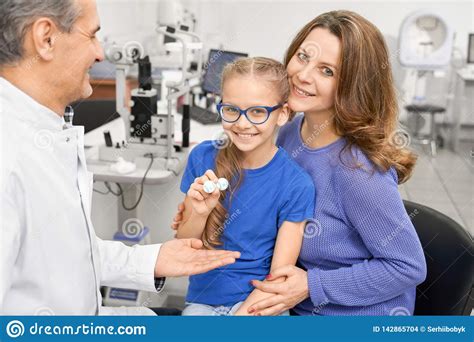 Mother With Daughter On Consultation In Ophthalmologist Stock Photo