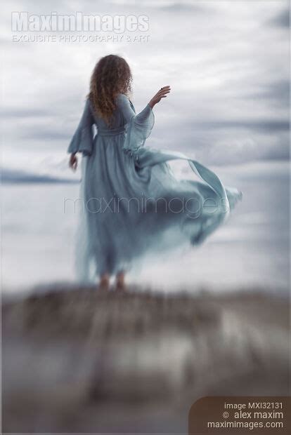 Photo Of Woman In A Long Elegant Dress Flying In The Wind Standing On