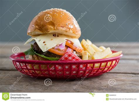 Cheeseburger And French Fries In Basket Against Wall Stock Image