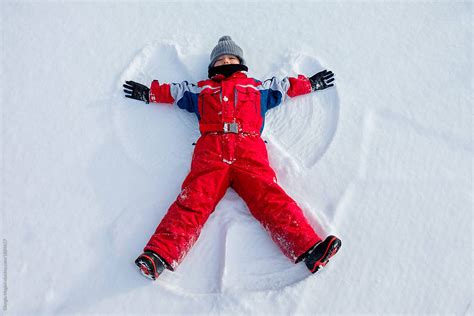 Child Making A Snow Angel By Stocksy Contributor Giorgio Magini