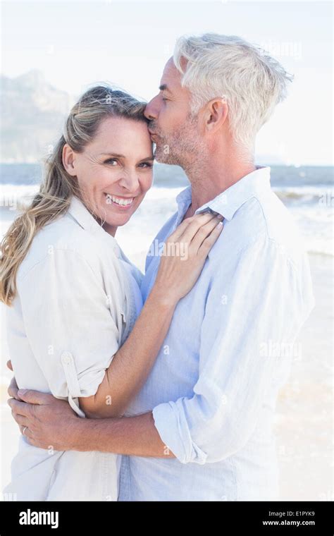 Man Kissing His Smiling Partner On The Forehead At The Beach Stock Photo Alamy