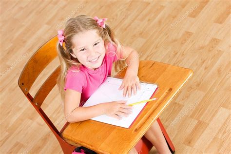 Student Smiling Girl Sitting At School Desk With Copyspace Stock Photo