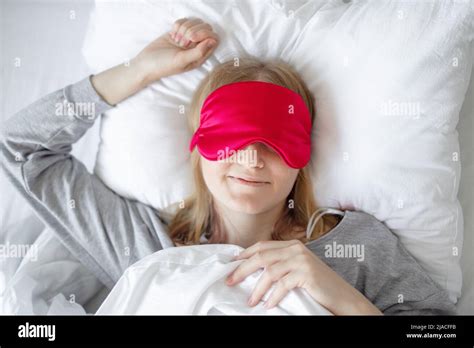 Top View From Above Blonde Woman Wearing Sleeping Mask Resting In Comfortable Bed At Home