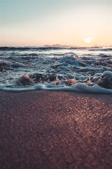 Sea Waves Crashing On Shore During Sunset · Free Stock Photo