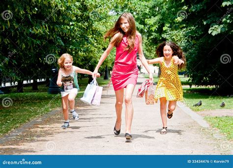 Mamá Con Los Niños Que Corren Alrededor En El Parque Foto De Archivo