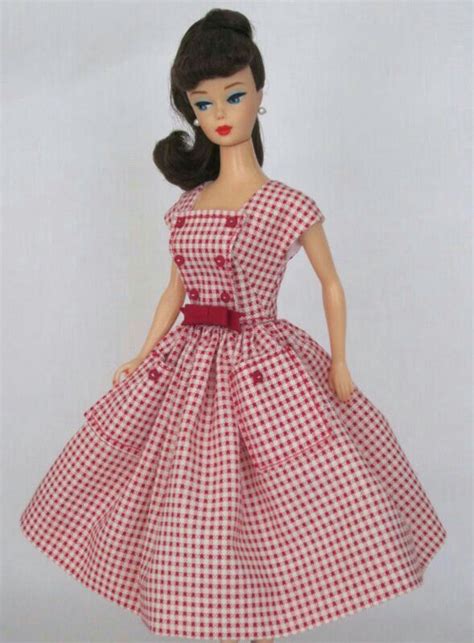 A Doll Wearing A Red And White Checkered Dress