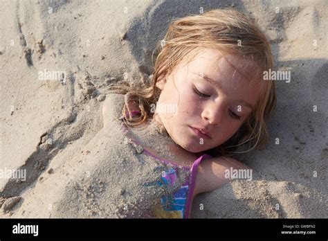 Girl Buried In The Sand At The Beach Stock Photo Alamy