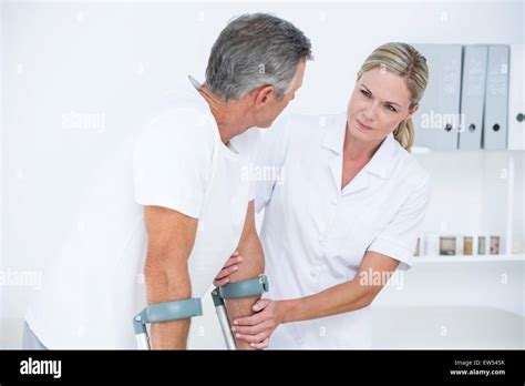 Doctor Helping Her Patient Walking With Crutch Stock Photo Alamy