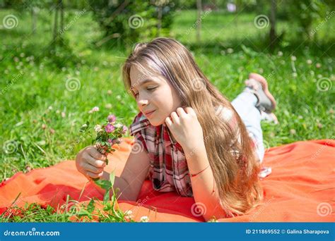 Une Jeune Fille De Ans Jouit D un Bouquet De Fleurs Sauvages Couché Sur La Pelouse Photo