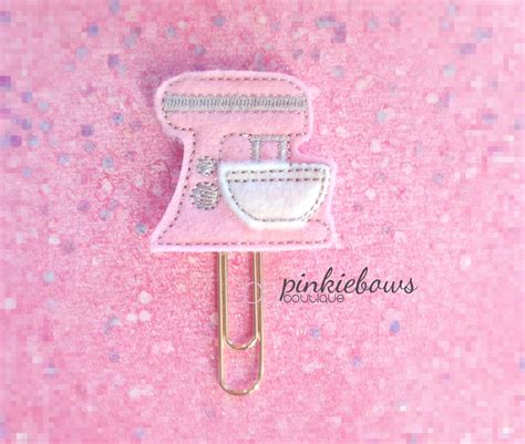 A Pink Paper Clip With A Sewing Machine On It