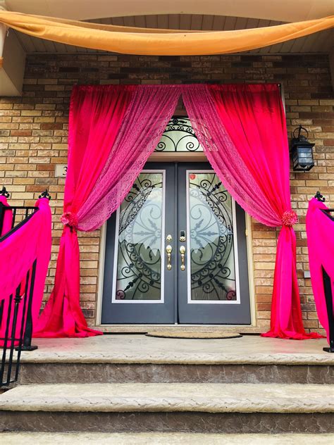 The Front Door Is Decorated With Bright Pink Drapes