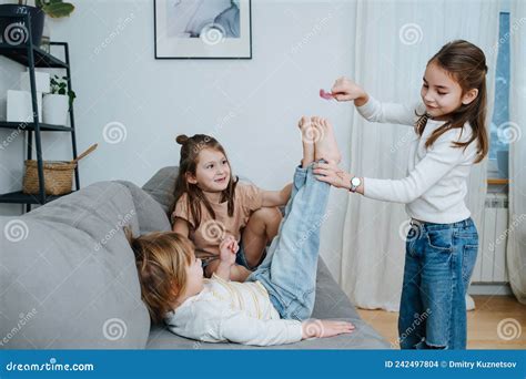Experimenting Girls Tickling Boy X S Feet With Feather Stock Photo Image Of Laugh