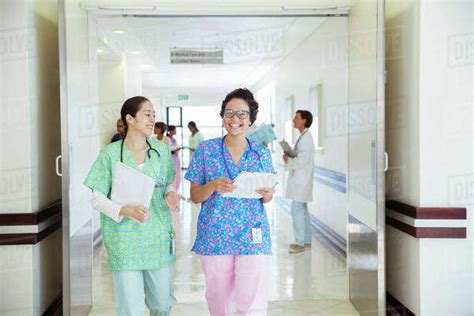Smiling Nurses Talking In Hospital Corridor Stock Photo Dissolve