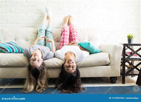 Women Having Fun While Lying Upside Down On Sofa Stock Photo Image Of