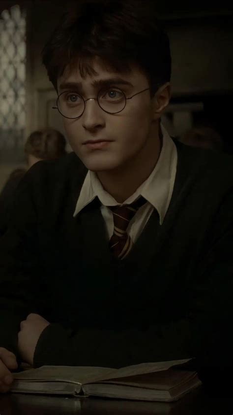 Harry Potter Sitting At A Table With An Open Book