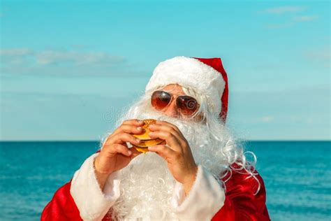 Santa Claus On The Beach Eating A Hamburger Stock Image Image Of
