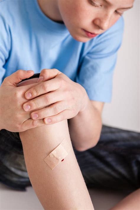 Boy With Bandage Covering Wound On Shin Stock Image Image Of Pensive
