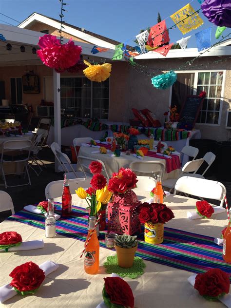 The Table Is Set Up For A Party With Paper Flowers And Tissue Pom Poms