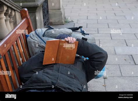 A Homeless Man In Edinburgh Relaxing On A Public Bench Reading The Stock Photo Alamy