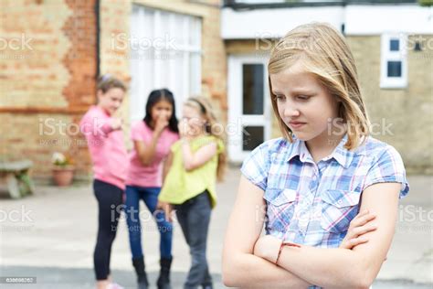 Unhappy Girl Being Gossiped About By School Friends Stock Photo