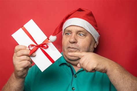 Funny Drunk Mature Man In Red Christmas Hat Holding Glass With Alcohol Sniffing Cigar And