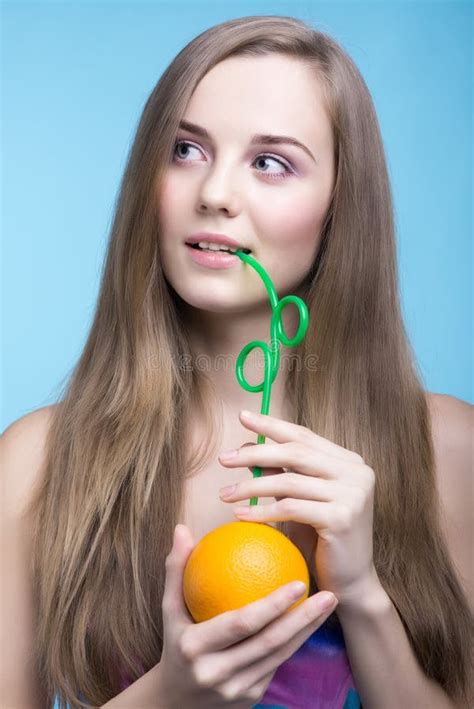 Beautiful Girl Drinking Orange Juice Through A Straw Stock Photo