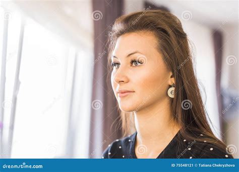 Молодая красивая девушка смотря в зеркало в салоне красоты Стоковое Изображение изображение