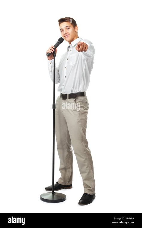 Young Man Singing Into A Microphone While Pointing Forward Isolated On