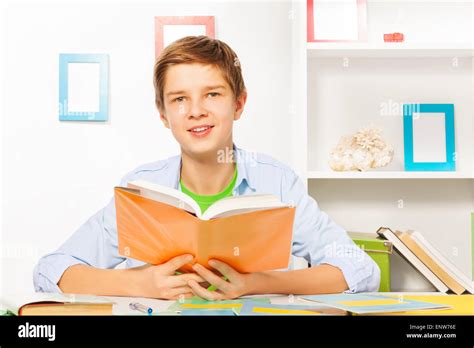 Nice Handsome Boy Read Orange Book And Do Homework Stock Photo Alamy