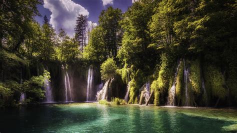 Multiple Waterfalls Pouring On River Surrounded By Green Leafed Trees