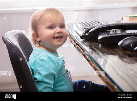 Portrait Of Cute Smiling Baby Girl Sitting On Chair Stock Photo Alamy