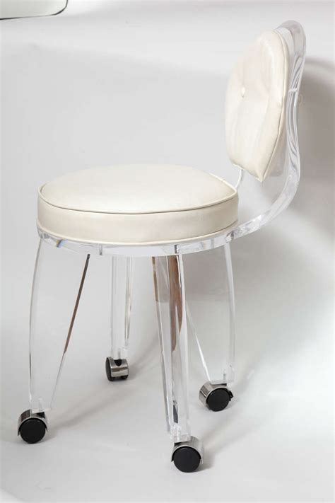 These chairs were made in 1970 out of one piece of lucite which was heated and then molded into the right shape. Lucite Upholstered Rolling Swivel Vanity Chair at 1stdibs