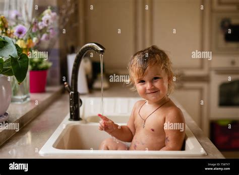 Baby Taking Bath In Kitchen Sink Child Playing With Foam And Soap