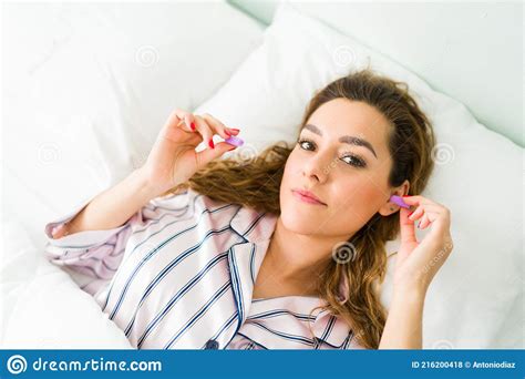 Gorgeous Woman Using Ear Plugs To Avoid The Noise Stock Photo Image