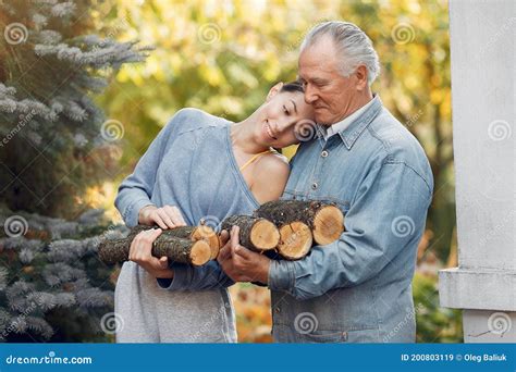 grandfather with granddaughter on a yard with firewood in hands stock image image of activity