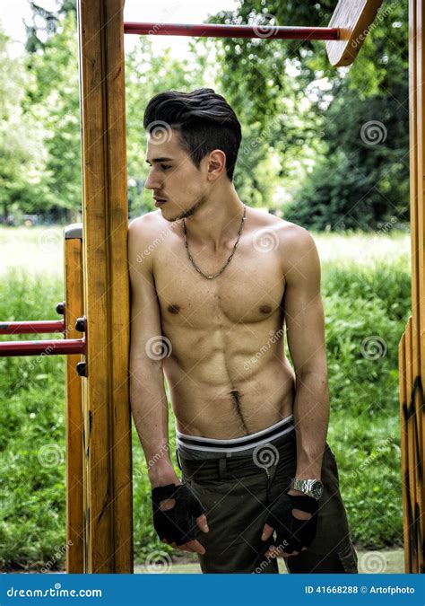 Handsome Shirtless Young Man Exercising In Outdoor Gym In Park Stock