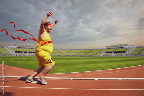 Fat Funny Man Runs To The Finish On Track In The Stadium Foto De Stock