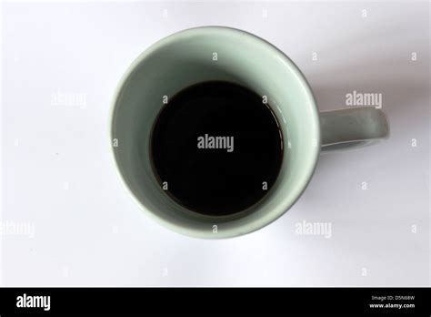 Looking Down Into A Green Mug Of Black Coffee Photographed In A Studio