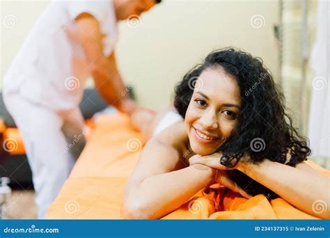 An Attractive Latin American Woman Lying Down On A Massage Bed At A Spa