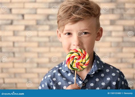 Cute Little Boy With Lollipop Near Brick Wall Stock Photo Image Of