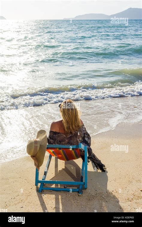Beautiful Woman Sunbathing In A Bikini On A Beach At Tropical Travel Resort Enjoying Summer