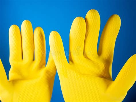 Pair Of Yellow Cleaning Gloves On A Blue Background Stock Photo Image
